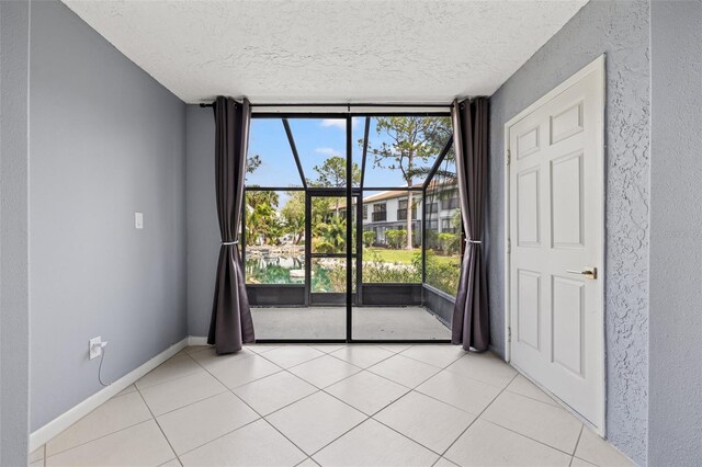 1998 Blue Hawk Ct Unit 1613, Clearwater, FL 33762 - empty room with a textured ceiling, expansive windows, light tile patterned flooring, and baseboards