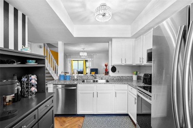 14019 Notreville Way, Tampa, FL 33624 - kitchen with a sink, white cabinetry, tasteful backsplash, stainless steel appliances, and an inviting chandelier