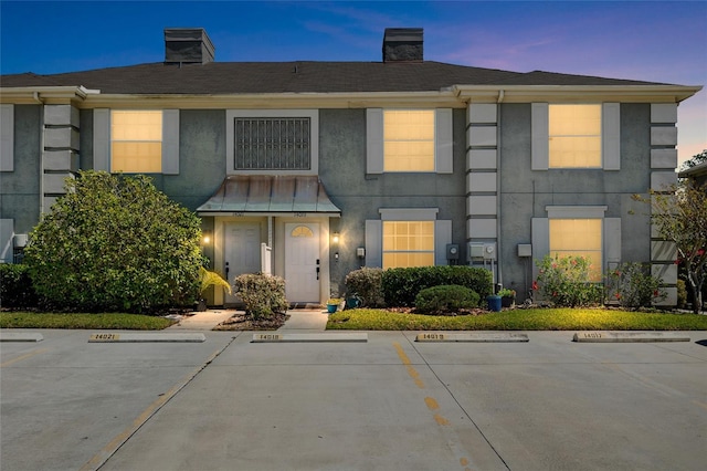 14019 Notreville Way, Tampa, FL 33624 - townhome / multi-family property with stucco siding, a chimney, and uncovered parking