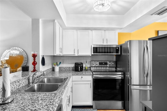14019 Notreville Way, Tampa, FL 33624 - kitchen featuring a sink, backsplash, appliances with stainless steel finishes, and white cabinets