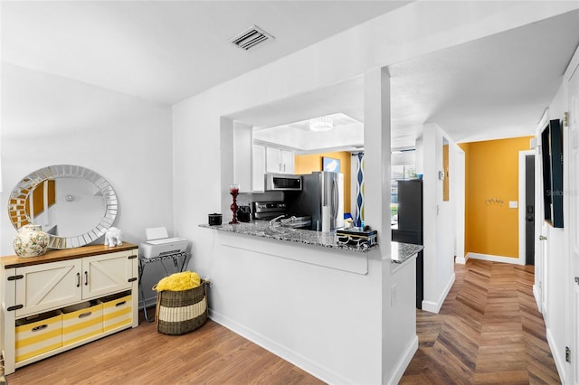 14019 Notreville Way, Tampa, FL 33624 - kitchen featuring white cabinets, visible vents, baseboards, light stone countertops, and stainless steel appliances