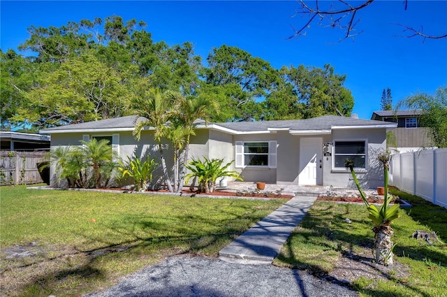 804 Shore Dr W, Oldsmar, FL 34677 - view of front of property featuring stucco siding, fence, and a front lawn