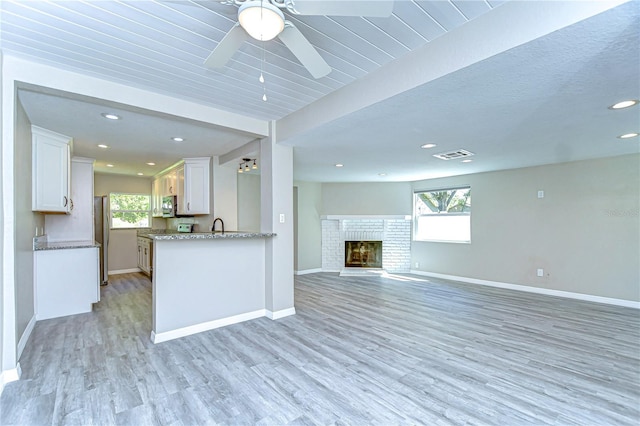 804 Shore Dr W, Oldsmar, FL 34677 - kitchen with baseboards, white cabinets, light wood-type flooring, and open floor plan