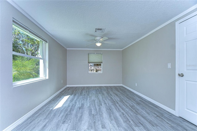 804 Shore Dr W, Oldsmar, FL 34677 - empty room featuring visible vents, baseboards, ornamental molding, wood finished floors, and a ceiling fan