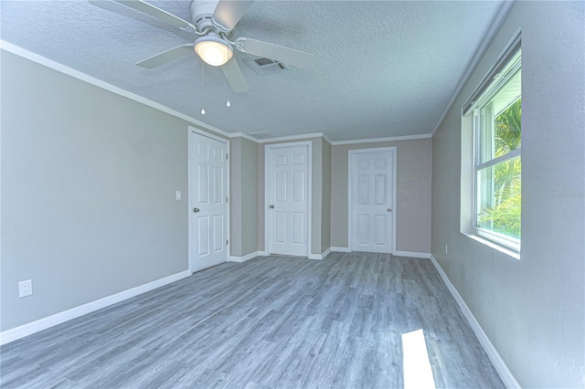 804 Shore Dr W, Oldsmar, FL 34677 - unfurnished bedroom featuring baseboards, visible vents, crown molding, and light wood-type flooring