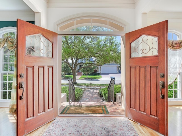 entryway featuring ornamental molding and wood finished floors