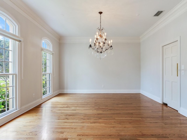unfurnished room with a chandelier, crown molding, light wood-style floors, and baseboards