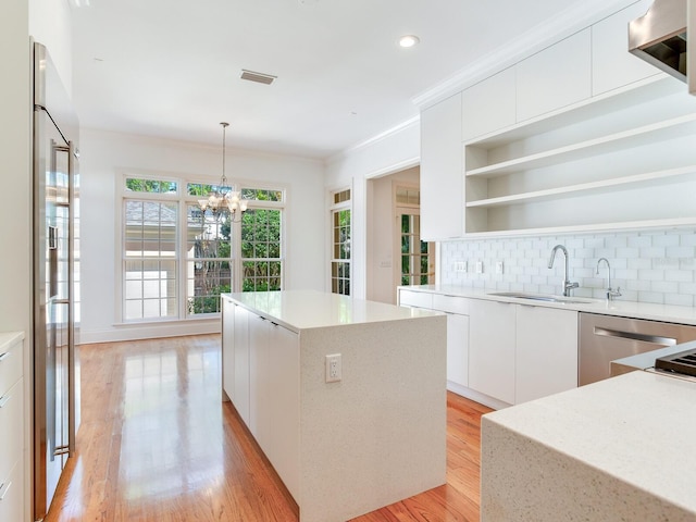 kitchen with open shelves, modern cabinets, a kitchen island, backsplash, and white cabinetry