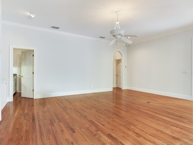 unfurnished room featuring crown molding, light wood-style flooring, baseboards, and ceiling fan