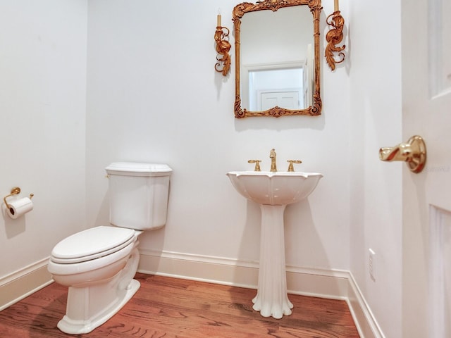 bathroom featuring toilet, wood finished floors, and baseboards