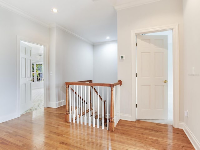 hall featuring an upstairs landing, light wood-style floors, crown molding, recessed lighting, and baseboards