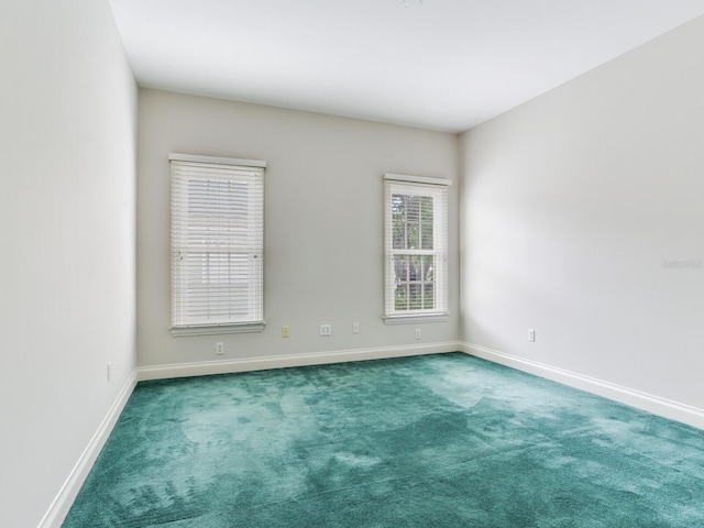 carpeted spare room with baseboards