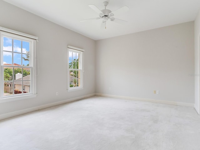 carpeted spare room with baseboards and a ceiling fan