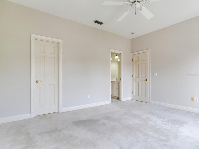 unfurnished bedroom featuring light carpet, baseboards, ensuite bathroom, and ceiling fan