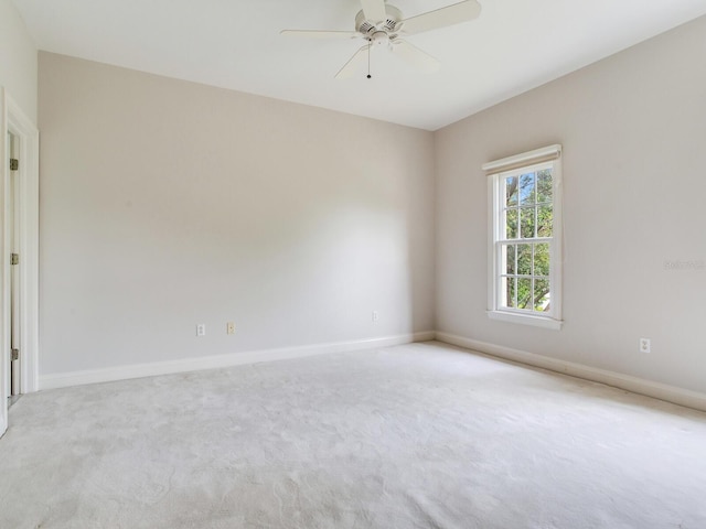 carpeted empty room with ceiling fan and baseboards