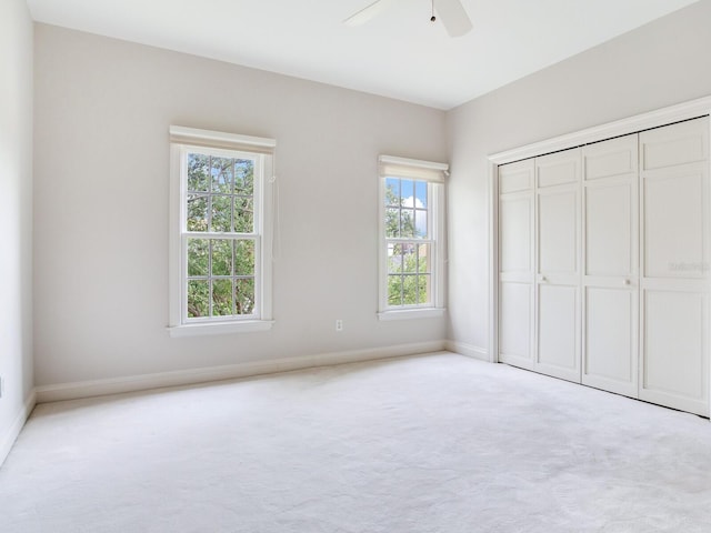 unfurnished bedroom featuring carpet floors, baseboards, a closet, and ceiling fan