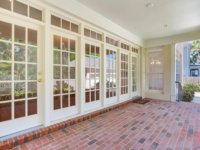 unfurnished sunroom featuring brick flooring and recessed lighting