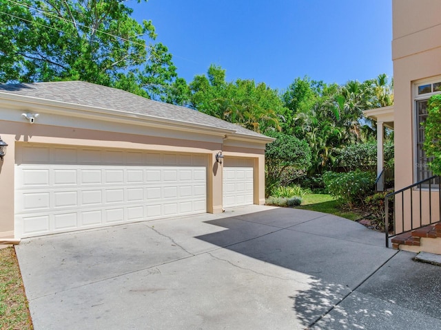 garage featuring concrete driveway