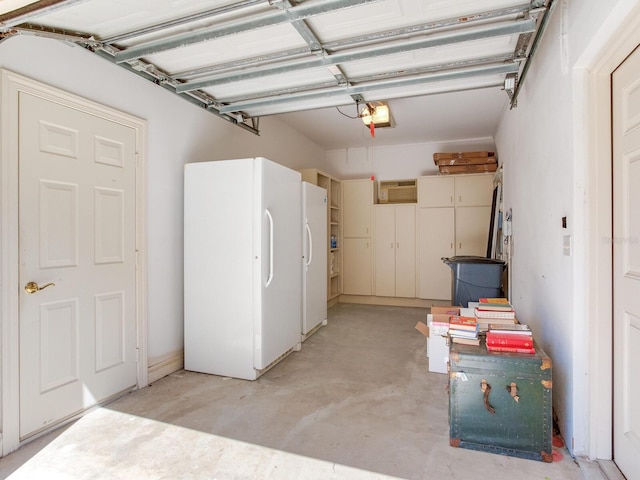 garage featuring freestanding refrigerator and a garage door opener