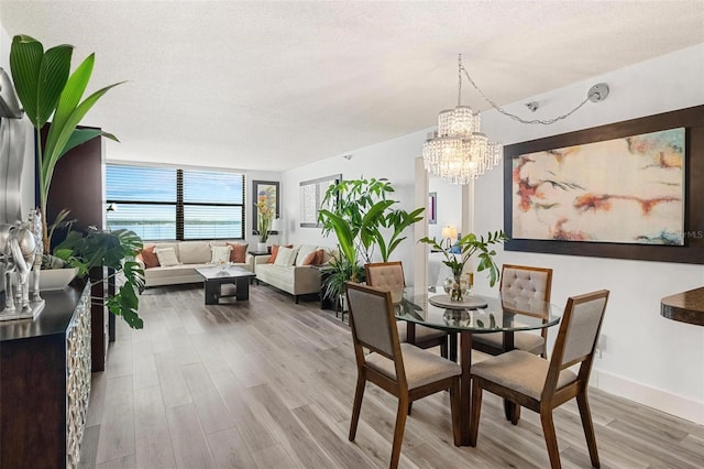 6265 Sun Blvd Unit 1201, Saint Petersburg, FL 33715 - dining space with a textured ceiling, wood finished floors, baseboards, and a chandelier
