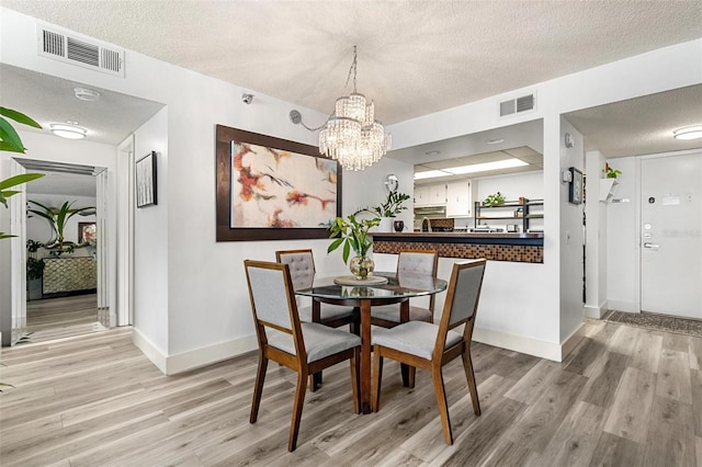 6265 Sun Blvd Unit 1201, Saint Petersburg, FL 33715 - dining area featuring light wood-type flooring, visible vents, and a notable chandelier