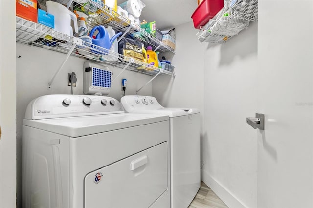 6265 Sun Blvd Unit 1201, Saint Petersburg, FL 33715 - clothes washing area featuring washing machine and clothes dryer, baseboards, light wood-style floors, and laundry area