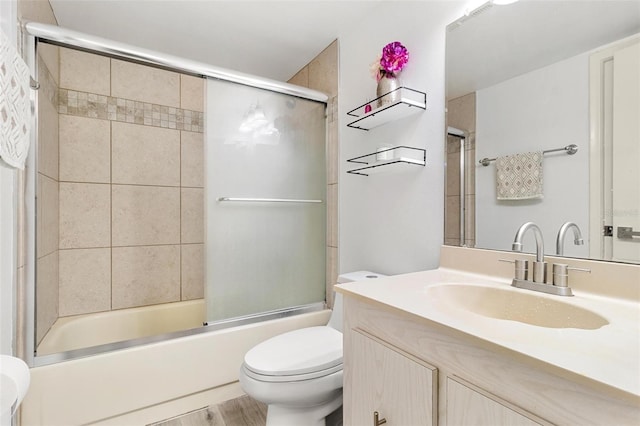 6265 Sun Blvd Unit 1201, Saint Petersburg, FL 33715 - full bath featuring combined bath / shower with glass door, wood finished floors, toilet, and vanity