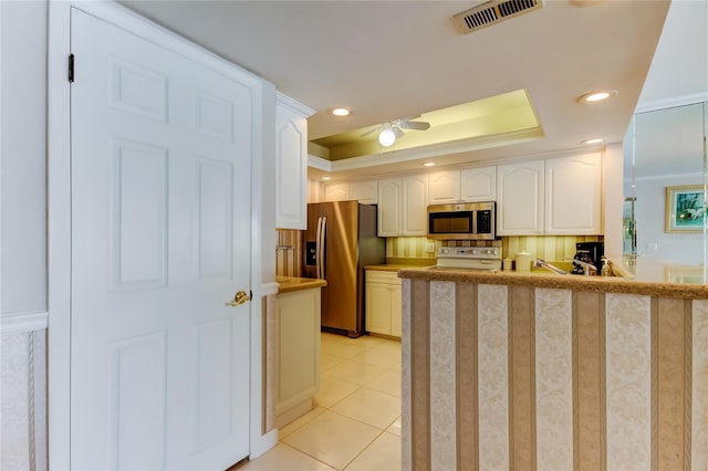 895 S Gulfview Blvd Unit 309, Clearwater Beach, FL 33767 - kitchen featuring white cabinetry, stainless steel appliances, a raised ceiling, visible vents, and a ceiling fan
