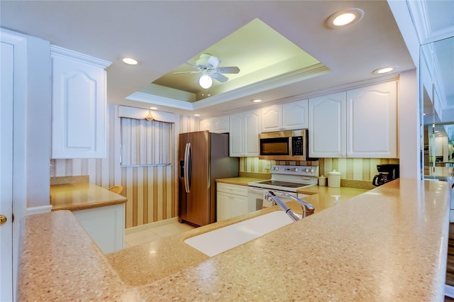 895 S Gulfview Blvd Unit 309, Clearwater Beach, FL 33767 - kitchen with white cabinetry, stainless steel appliances, a raised ceiling, a sink, and a ceiling fan