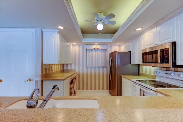 895 S Gulfview Blvd Unit 309, Clearwater Beach, FL 33767 - kitchen with a tray ceiling, crown molding, a sink, white cabinetry, and appliances with stainless steel finishes