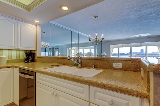 895 S Gulfview Blvd Unit 309, Clearwater Beach, FL 33767 - kitchen featuring stainless steel dishwasher, a sink, pendant lighting, white cabinets, and a notable chandelier