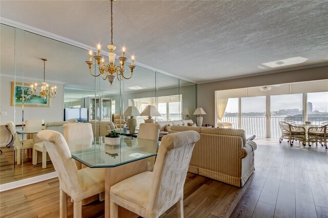 895 S Gulfview Blvd Unit 309, Clearwater Beach, FL 33767 - dining room featuring hardwood / wood-style floors, crown molding, and a notable chandelier