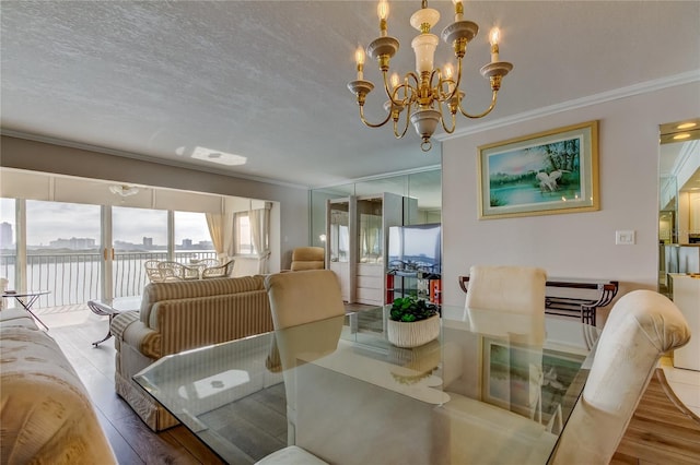 895 S Gulfview Blvd Unit 309, Clearwater Beach, FL 33767 - dining area featuring wood finished floors, a notable chandelier, crown molding, and a textured ceiling