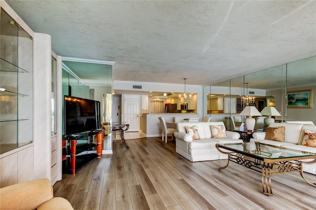 895 S Gulfview Blvd Unit 309, Clearwater Beach, FL 33767 - living room featuring visible vents, ornamental molding, wood finished floors, and a chandelier