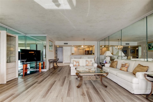 895 S Gulfview Blvd Unit 309, Clearwater Beach, FL 33767 - living room featuring visible vents, a notable chandelier, crown molding, and wood finished floors