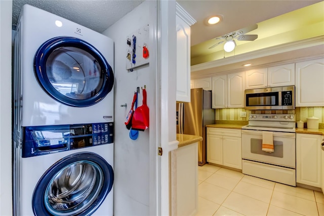 895 S Gulfview Blvd Unit 309, Clearwater Beach, FL 33767 - laundry area featuring recessed lighting, a textured ceiling, stacked washer and dryer, light tile patterned flooring, and laundry area