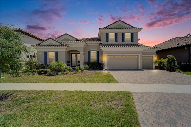 14239 Swiss Bridge Dr, Riverview, FL 33579 - mediterranean / spanish-style home with a tiled roof, a front yard, decorative driveway, an attached garage, and stucco siding