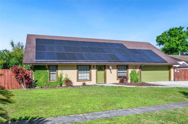 5235 Nichols Dr E, Lakeland, FL 33812 - view of front of house featuring stucco siding, fence, a front lawn, a garage, and roof mounted solar panels