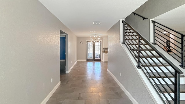 5235 Nichols Dr E, Lakeland, FL 33812 - corridor featuring stairs, a notable chandelier, baseboards, visible vents, and a textured wall