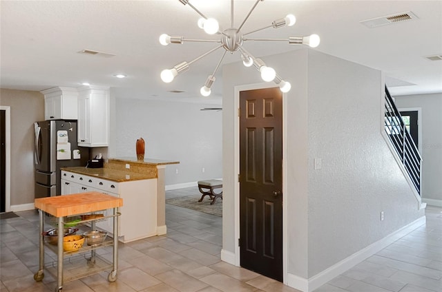 5235 Nichols Dr E, Lakeland, FL 33812 - kitchen with baseboards, visible vents, white cabinetry, and freestanding refrigerator