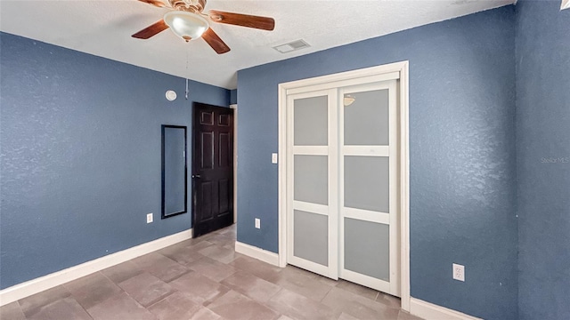 5235 Nichols Dr E, Lakeland, FL 33812 - unfurnished bedroom featuring a textured wall, baseboards, ceiling fan, and visible vents