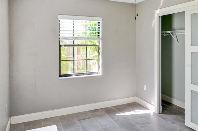 5235 Nichols Dr E, Lakeland, FL 33812 - unfurnished bedroom with baseboards, a closet, and tile patterned flooring