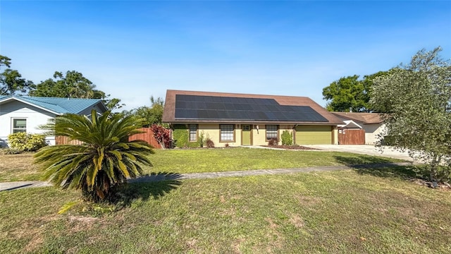 5235 Nichols Dr E, Lakeland, FL 33812 - view of front of home with fence, roof mounted solar panels, an attached garage, concrete driveway, and a front yard