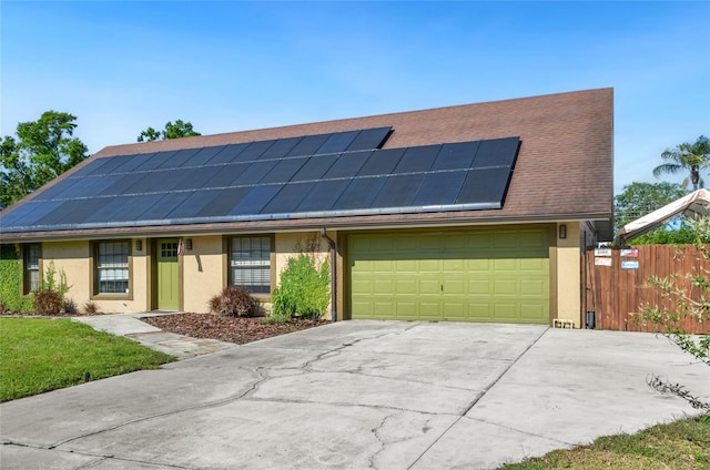 5235 Nichols Dr E, Lakeland, FL 33812 - view of front of property with stucco siding, fence, an attached garage, driveway, and roof mounted solar panels