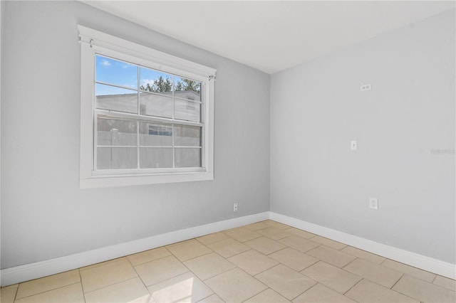 unfurnished room featuring baseboards and light tile patterned floors