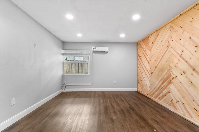unfurnished room with recessed lighting, a wall mounted AC, baseboards, and wood finished floors