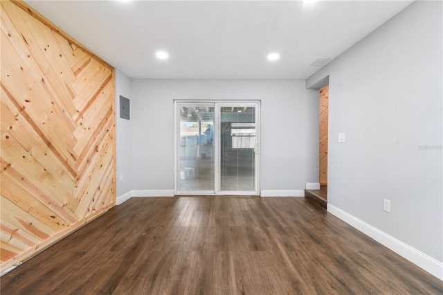 spare room featuring baseboards, recessed lighting, and dark wood finished floors