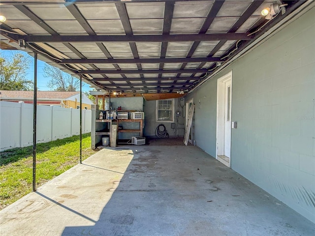 view of patio / terrace with an attached carport and fence