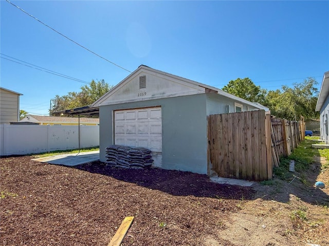 detached garage featuring fence