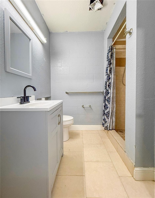 full bath featuring a shower stall, baseboards, toilet, tile patterned floors, and vanity